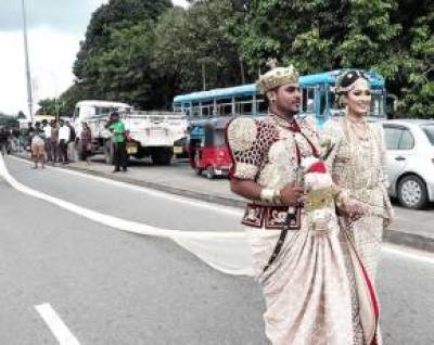  نوبیاہتا سری لنکن دولہا دلہن سڑک پر چل رہے دلہن کا 3.2 کلومیٹر سب سے لمبا شادی کا لباس
